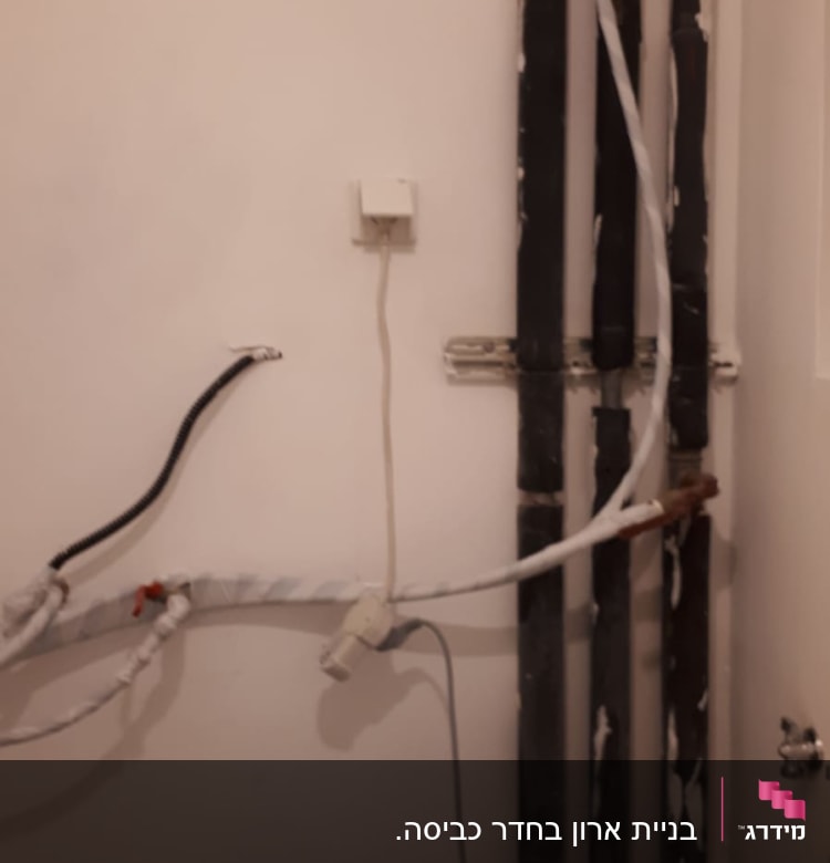 צינורות חשמל וקיר עם מטאטא קטן